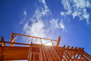 New construction home framing against blue sky,