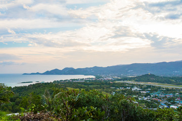View of Koh Samui island from a nearby mountain with an airport strip and town in the background, Thailand.