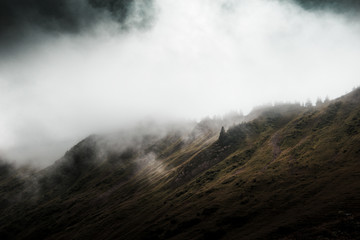 Dark ominous mountain landscape with low clouds