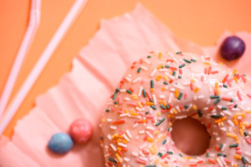 Sprinkled Pink Donut. Frosted sprinkled donut on pink background.