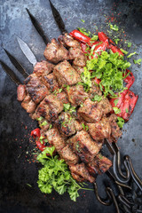 Traditioneller russischer Schaschlik Grillspieß mit Paprika als Draufsicht auf schwarzen Board 