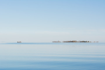 Fototapeta na wymiar The lake and a ship on the horizon