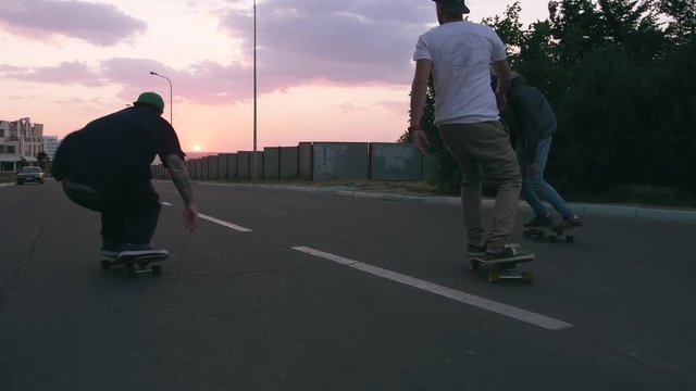 Group of young people skateboarding on the road in the early morning, cinematic shot, slow motion