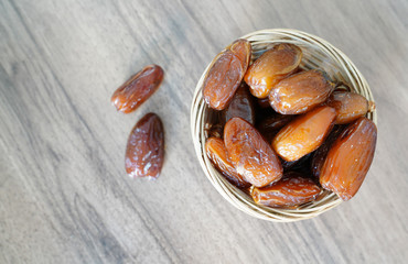 Fresh fruit dates in a basket bowl on walnut wooden table