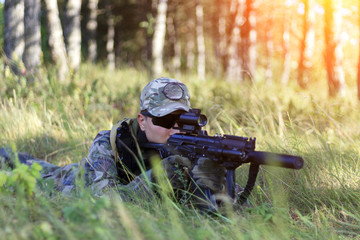 The sniper lies in wait, looks through the scope, toned