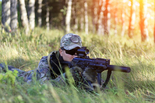 The sniper lies in wait, looks through the scope, toned