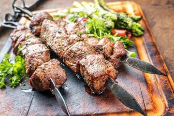 Traditional Russian shashlik on a barbecue skewer with green asparagus and paprika as close up on a...