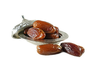 Fresh fruit dates in a silver metal bowl on isolated white background