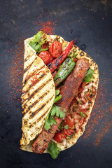 Traditional Adana Kebap with tomato and salad on a flatbread with copy space
