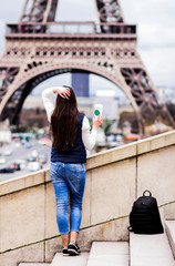 Paris. The girl in Paris. Eiffel Tower. photo with a view of the tower. concepts of coffee with you in Paris. tourist travel girl in jeans pants with long dark hair. background without face