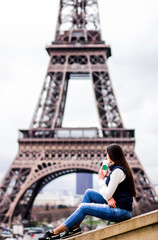 Paris. The girl in Paris. Eiffel Tower. photo with a view of the tower. concepts of coffee with you in Paris. tourist travel girl in jeans pants with long dark hair. background without face