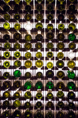 Wall of empty wine bottles. Empty wine bottles stacked-up on one another in pattern lit by the light coming from behind