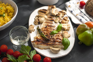 White fish on the river and drink. Delicious dinner on a black table.