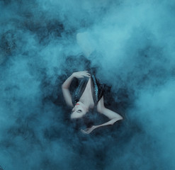 The dark vampire queen lies in the embrace of the fogs on her black dress with a deep neckline. The...