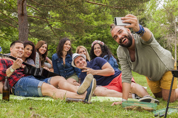 freunde machen gruppen selfie während eines picknicks im stadtpark. alle feiern und haben spass...