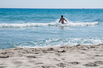 Young man in waves in the sea (Porto Pino, Sardinia)