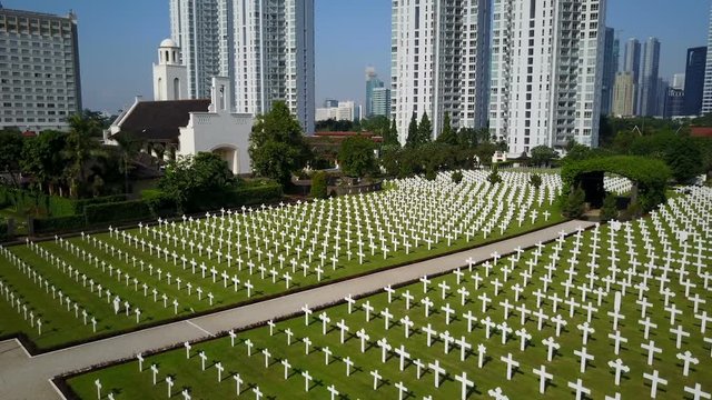 Slow aerial view of serene cemetery for fallen Dutch citizens and soldiers at Menteng Pulo war memorial in Jakarta
