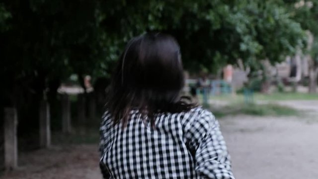 Back view of girl, who is walking and suddenly running