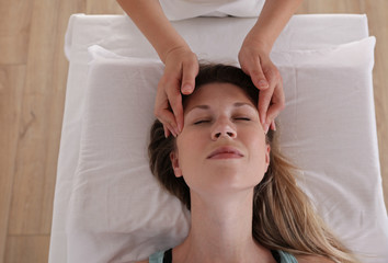 Fototapeta na wymiar Woman enjoying head massage. Acupressure treatment. Relaxation and Alternative medicine conept