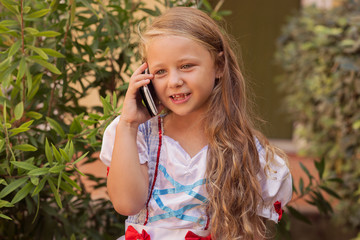 Little girl in dress speaking on phone