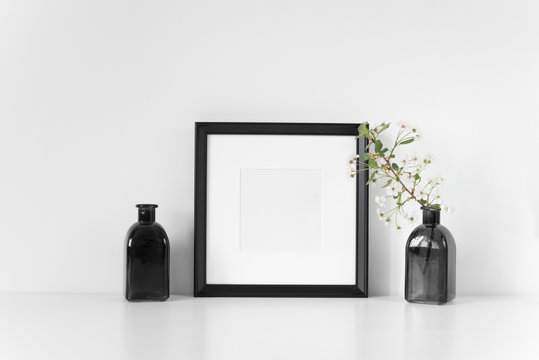 Black square frame mockup with spring cherry branch. Mock up for your photo, design or text.