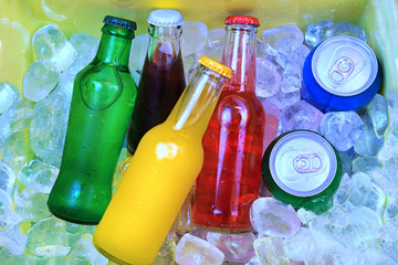 Colorful cold soda drinks, filled ice cubes in a cool box