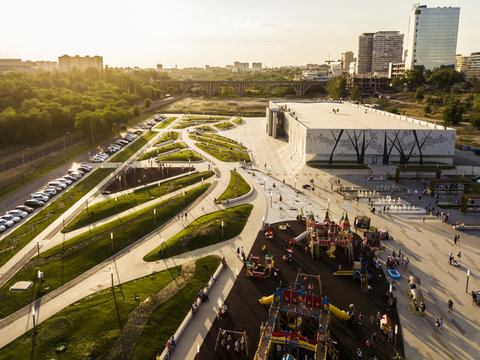 Aerial Green Trees City With Parking And Walking Zone, Children Playing On The Ground