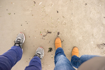 Fototapeta premium Two people legs walking on beach