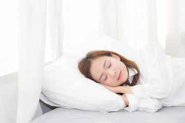 Fototapeta na wymiar Beautiful asian young woman sleeping lying in bed on bedroom with head on pillow comfortable and happy, girl with relax for health welness and lifestyle concept.