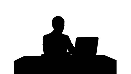 Silhouette Young businessman concentrating on working with laptop computer