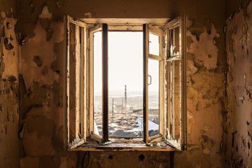 A ruined window in an abandoned building, view from the inside