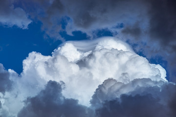 White fluffy clouds surrounded by thunderstorm clouds