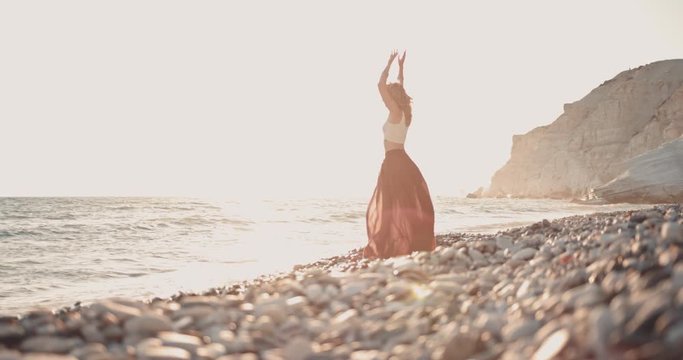 Hippie woman with arms outstretched relaxing at the beach