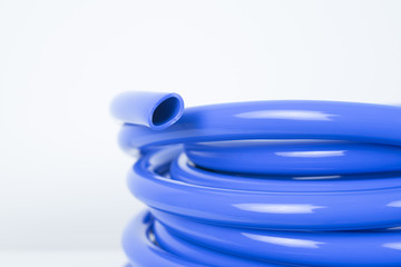 Blue plastic hose close up on white background.