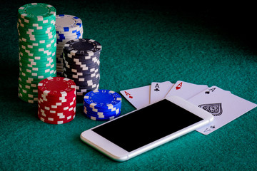 smart phone with casino chips and poker of aces
