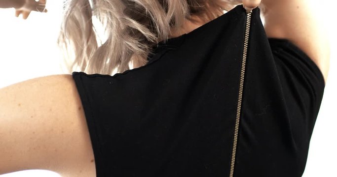 Attractive woman trying on new black dress, zipping up and heading out after shopping