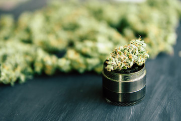 Macro of marijuana bud with trichomes and crushed weed in a grinder