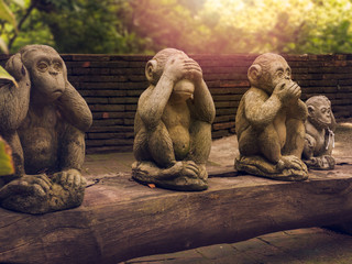 three monkeys statues which have different posts. © kukiat