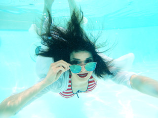 beautiful woman portrait underwater with sunglasses