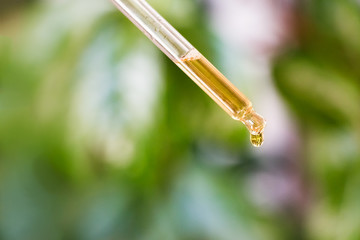 Dropper with liquid spilling a drop.