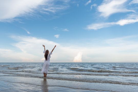 Happy Young Woman Raised Hands Up On The Beach With Happily On Blue Sky And Sea, Time To Traveling Concept.