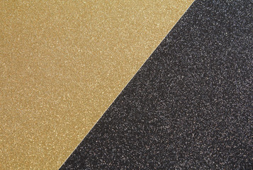 A close up of gold craft glitter paper placed against black craft glitter paper to create a black & gold textured background.