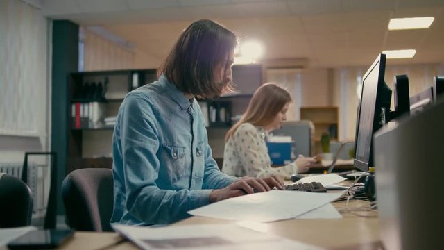 Young Professional Designer is Working at the Computer in the Office of StartUp Company