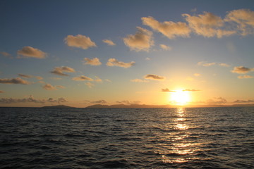 Fototapeta premium Sunrise over water blue skies and clouds