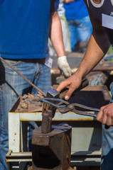 blacksmith performs the forging of hot glowing metal on the anvil