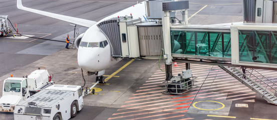 Obraz premium avion gros-porteur relié à sa passerelle d'embarquement