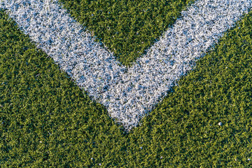 Background from a white line on a green artificial soccer field © elxeneize