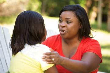 African American mother hugghing her daughter.