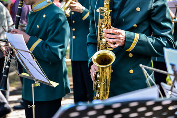 Performance of the brass band at the city festival. Musicians with french horn, trumpet, trumpet,...