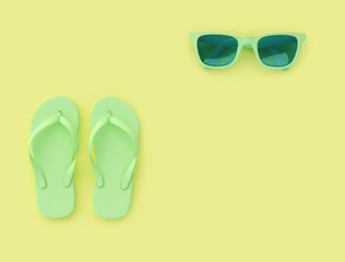 Flip flops and sunglasses on yellow background,  summer vacation concept